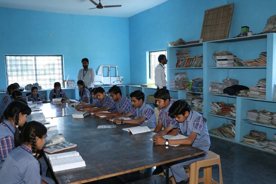 Students reading at long tables in the school library